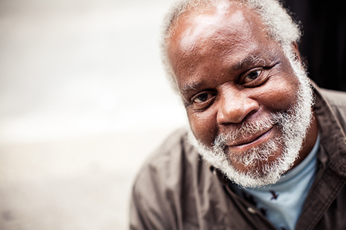 African American man with grey beard smiling at the camera